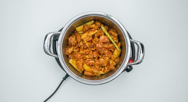 As soon as the Audiotherm beeps on reaching the roasting window, set at level 2, add chicken and roast. Add dripping wet potatoes and lemon grass and stir everything.