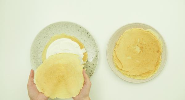 Spread every pancake with the mass and stack each on top of the other. Serve garnished with the remaining mass and some fresh fruits.