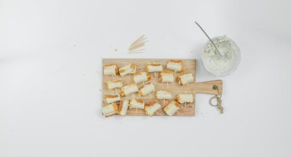 Smear a little cheese cream on the bread strips, roll up, secure with toothpicks.