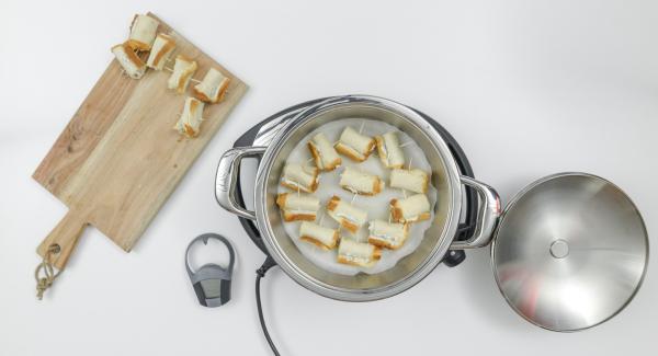 As soon as the Audiotherm beeps by reaching the roasting window, place the baking paper and half of the rolls inside the pot.