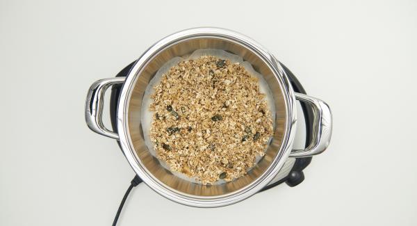 As soon as the Audiotherm beeps on reaching the roasting window, put in baking paper, spread the granola mixture on it and place the pot into the inverted lid.