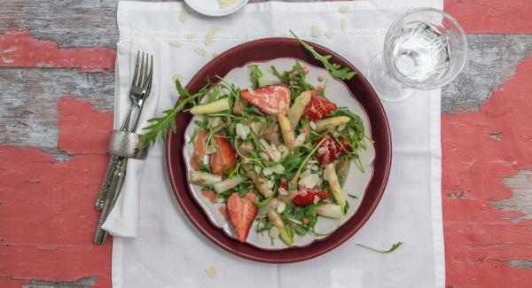 Let the asparagus cool down. Clean strawberries and halve. Purée about a quarter of the strawberries with honey, vinegar, oil as well as the asparagus stock. Season with salt and pepper. Clean rocket and tear in small pieces. Mix with asparagus and remaining strawberries. Drizzle the cooled vinaigrette over it and serve sprinkled with almonds.