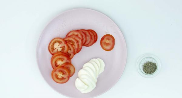 When the dough is still hot, add a few slices of tomato, a few pieces of mozzarella and oregano. Serve.