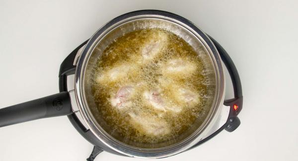 As soon as the Audiotherm beeps on reaching the roasting window, set at level 2 and put half of the wings in the pot. Close with the lid.