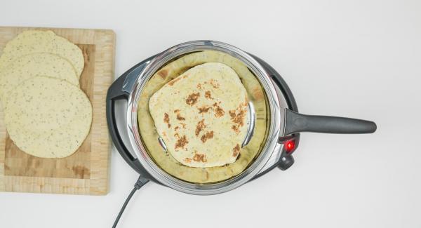 As soon as the Audiotherm beeps on reaching the roasting window, set at level 2, put in the first dough and put on the lid. Bake the first side for approx. 1 minute. Turn the flatbread over and roast for approx. 1 minute.