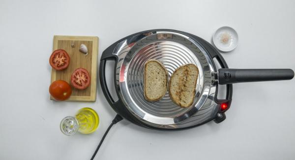 Set Navigenio to low level, place 2 slices of bread in the oPan and roast on one side. Turn and rub bread with tomato and garlic.