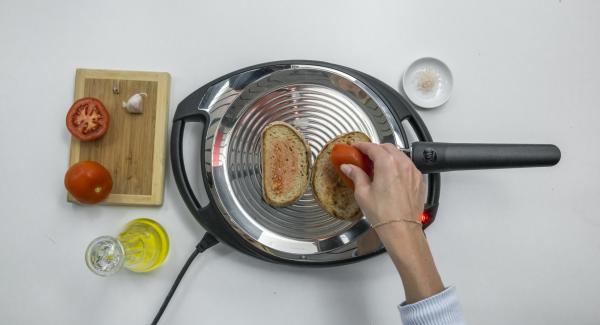 Set Navigenio to low level, place 2 slices of bread in the oPan and roast on one side. Turn and rub bread with tomato and garlic.