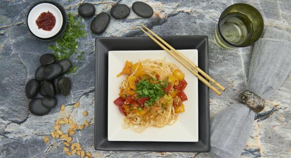 Add the peanuts to the vegetables and bring to boil. Season with Sambal Oelek, soy sauce and pepper. Add the pasta and cilantro and mix well.