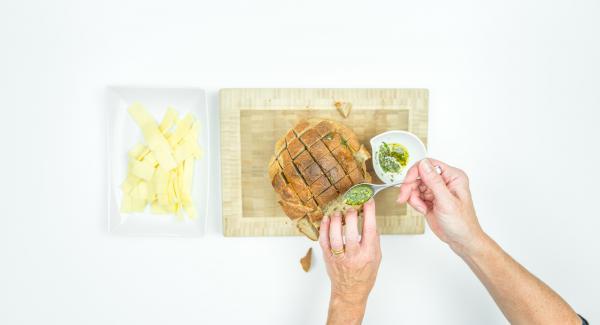 Fill the olive oil mixture into the cuts. Cut the cheese into strips and also place them inside the cuts.