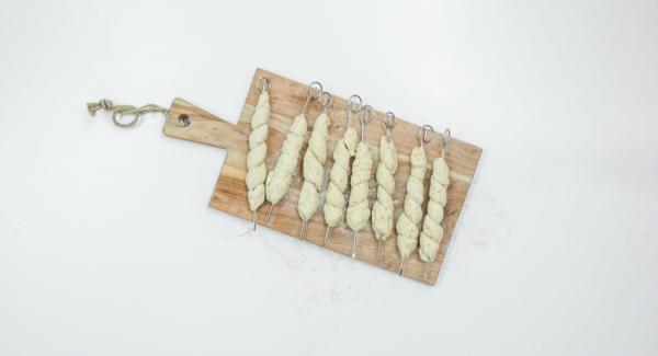 Wrap the dough in a spiral around the skewers, press the ends well. Cover and leave to rest for 5 minutes.