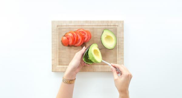 Stone the avocado, remove the fruit pulp with a spoon and spread it on the toasts.