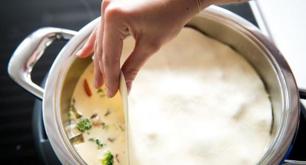 Pour egg and cream mixture over the vegetables and cover with the dough sheet.