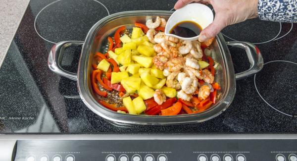 Add prawns and pineapple, reheat everything, season with soy sauce.