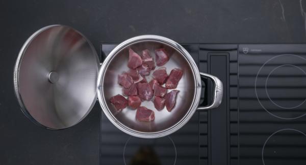 As soon as the Audiotherm beeps when reaching the roasting window, switch to low level and roast goulash all around. Add the onion mixture and roast briefly.